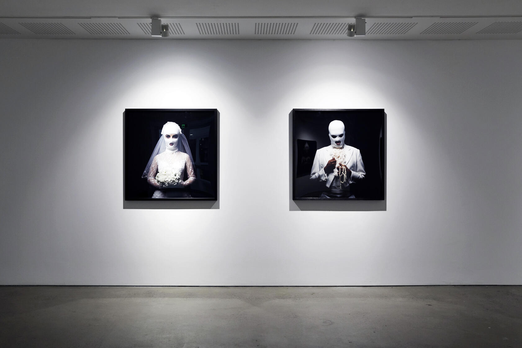 Installation view of two artworks mounted on a white wall