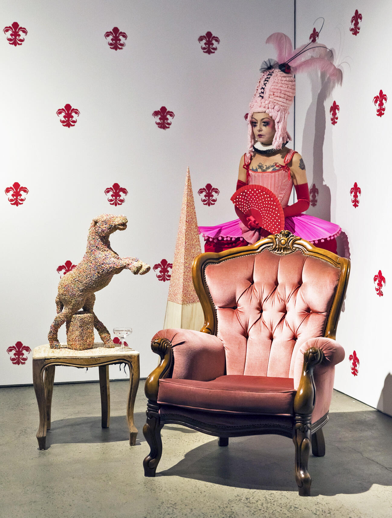 A figure of a person standing behind a chair. 
