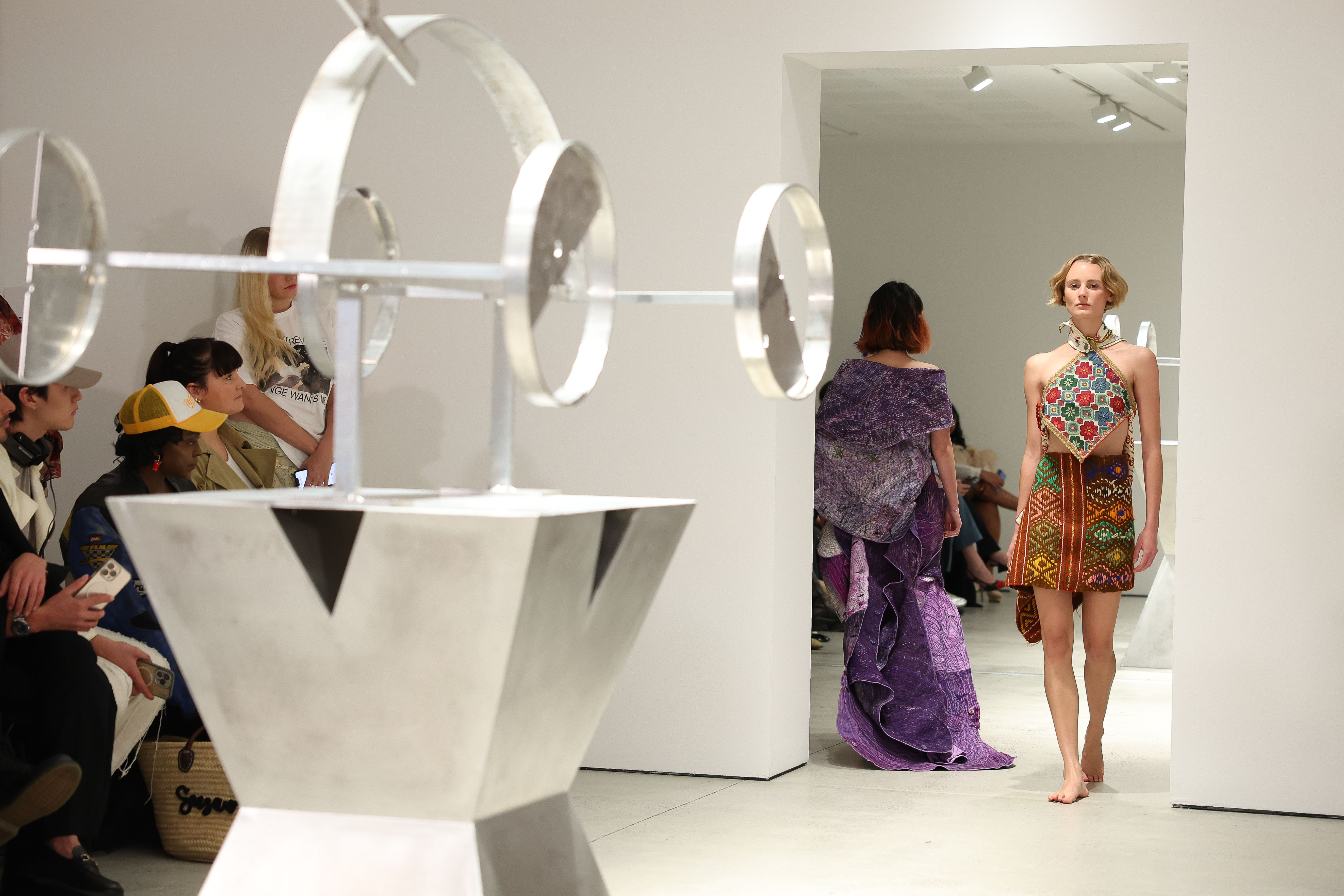 Runway and audience watching in white gallery