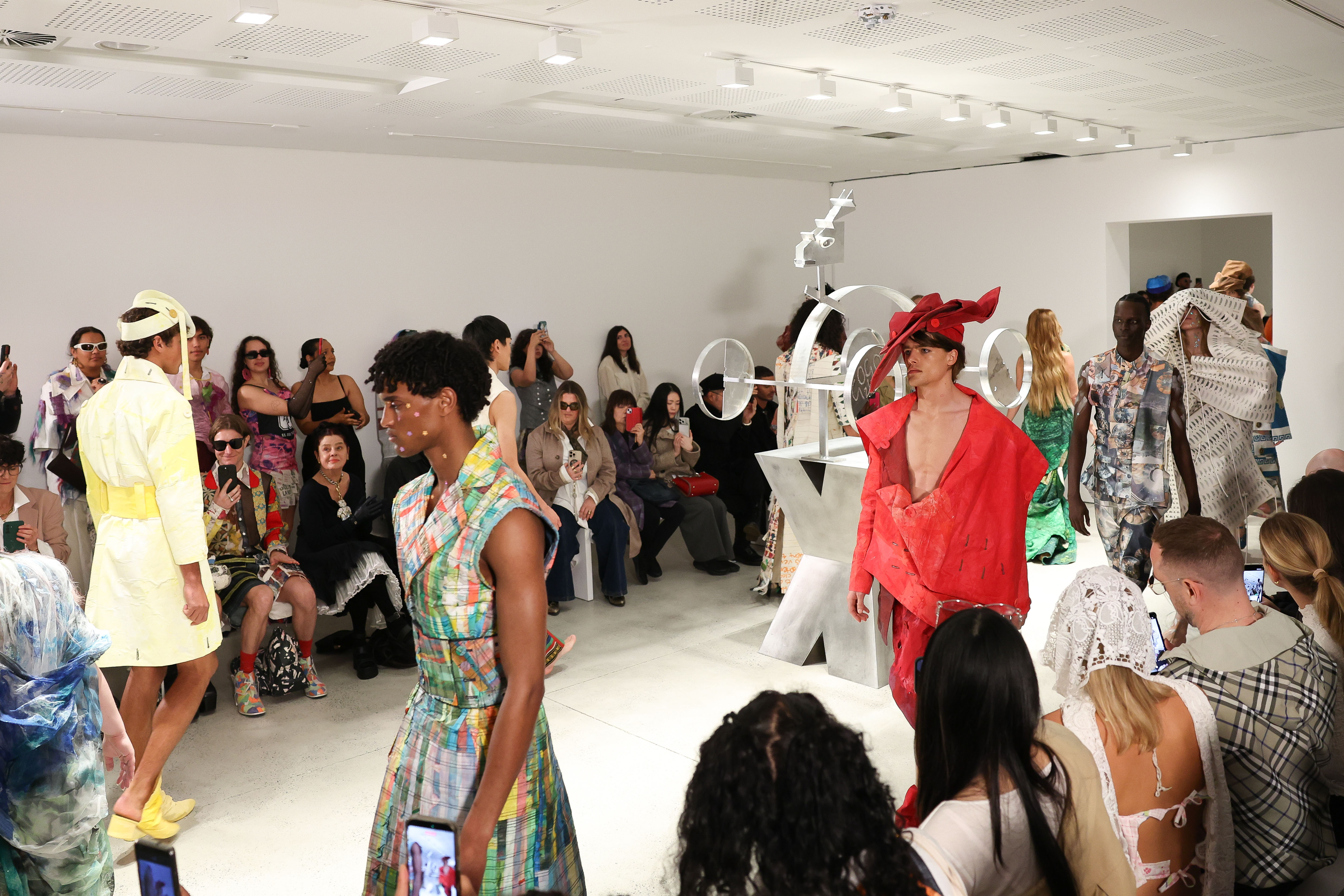 Runway and audience watching in white gallery