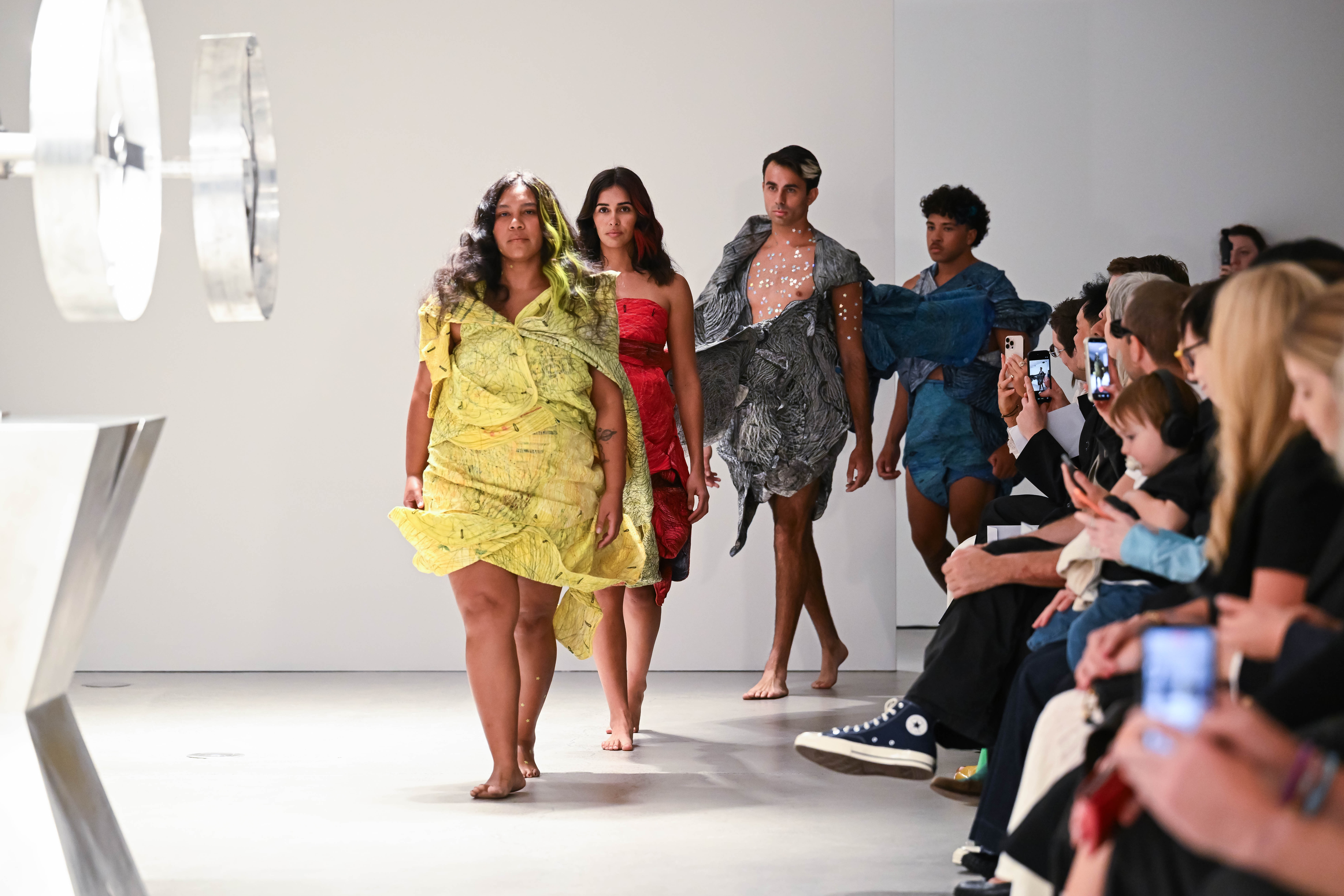 Runway and audience watching in white gallery