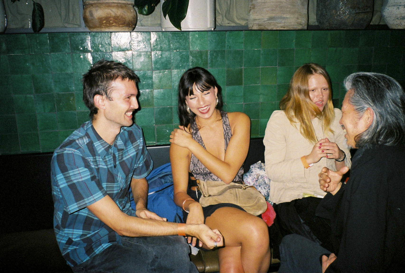 people laughing sitting on bar bench
