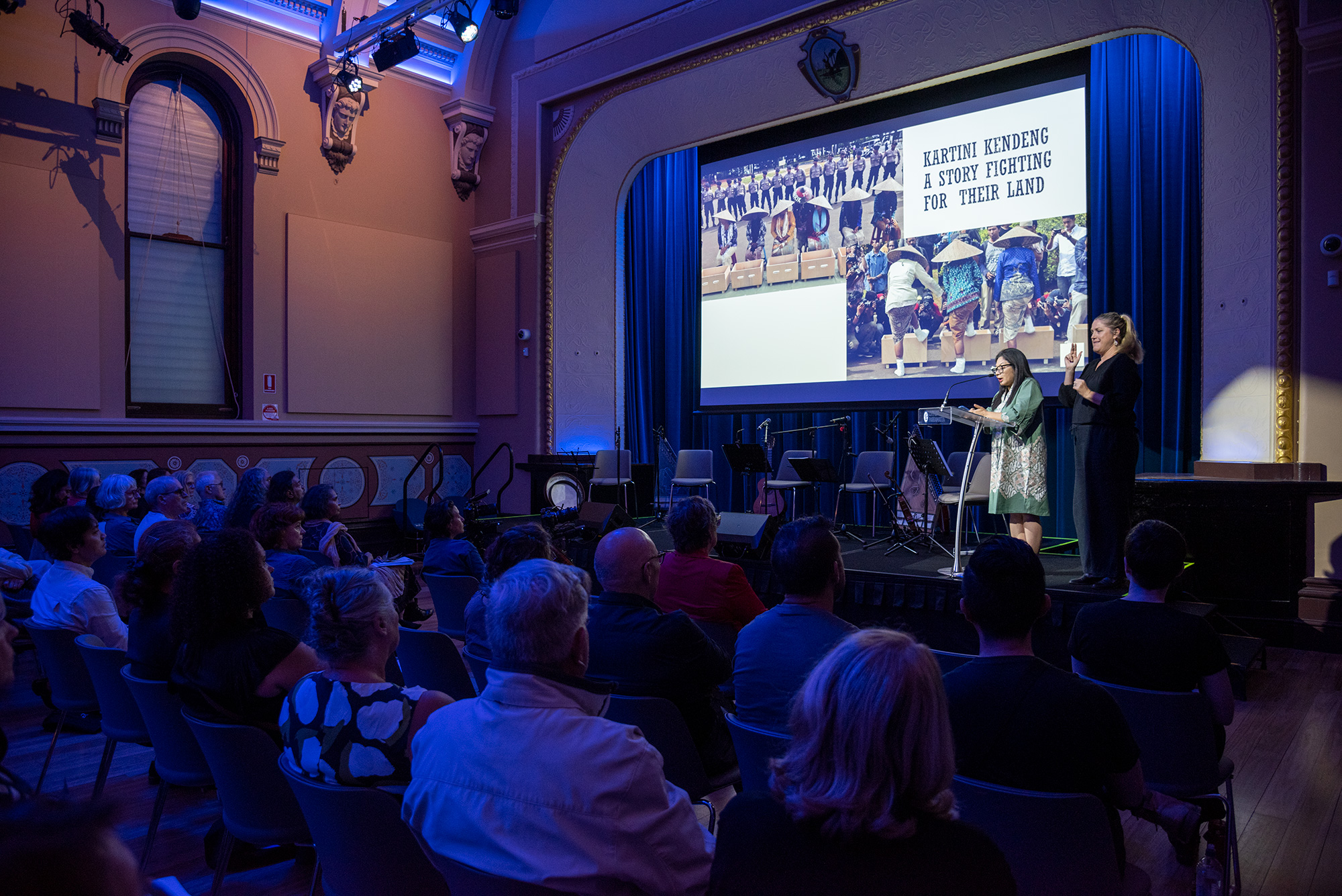 Alia Swastika presenting to a large crowd alongside Auslan Interpreter