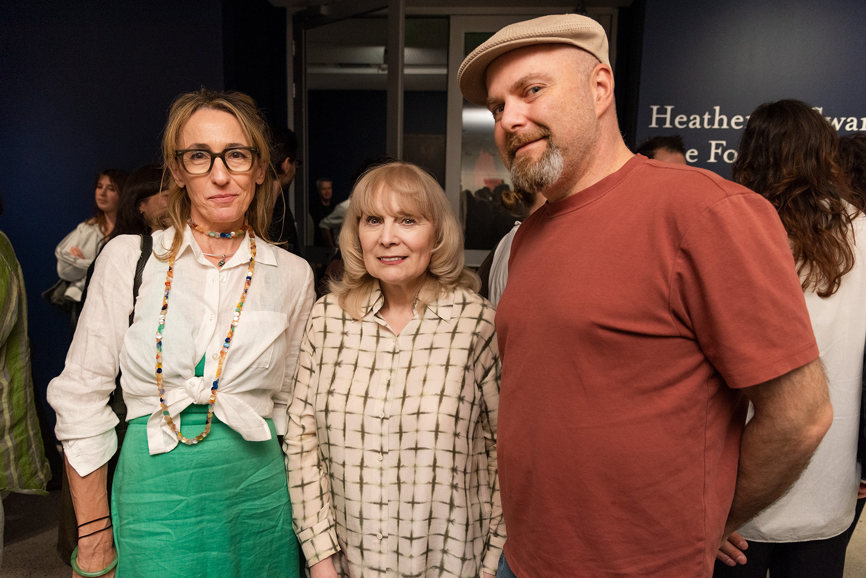 Copyright Agency representatives pose together at a exhibition opening, with other visitors gathered in the gallery behind them.