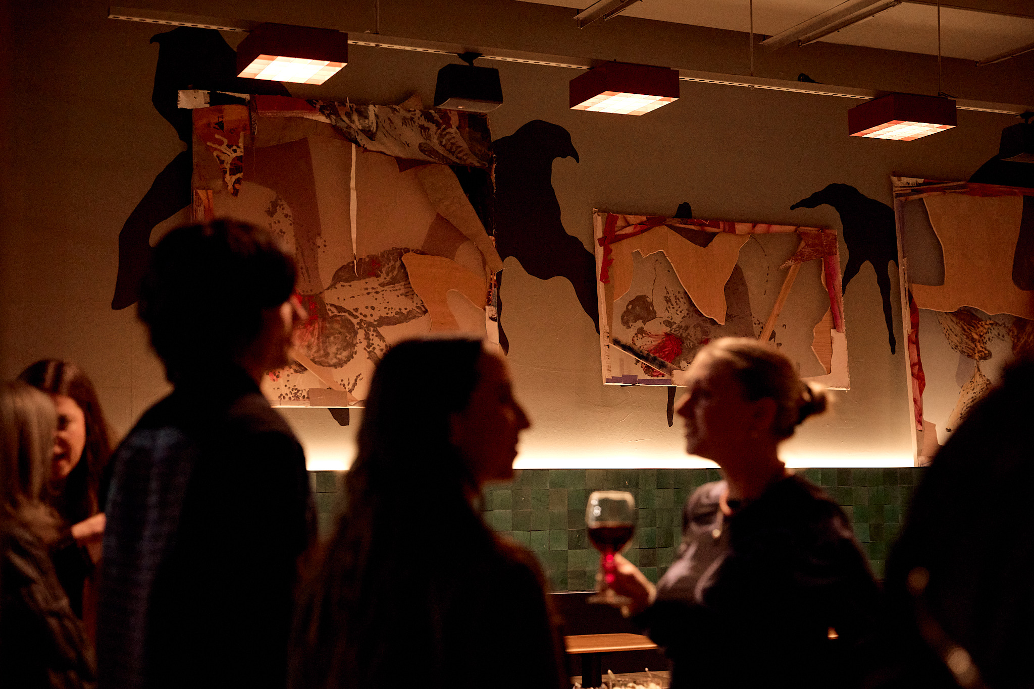 People talking in Ace Hotel in front of artwork