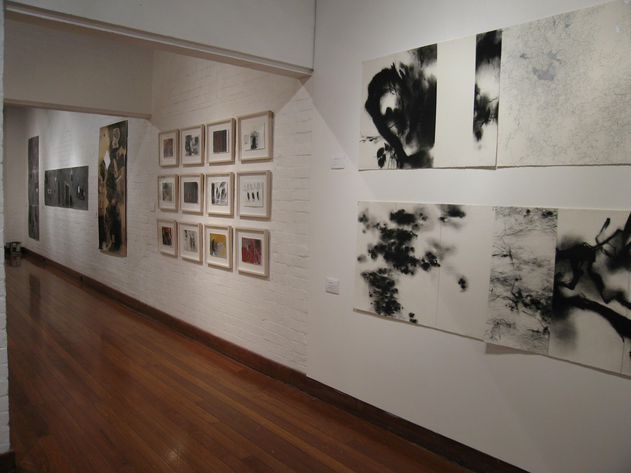 Installation featuring multiple prints, and drawings arranged directly on the wall in a structured layout.