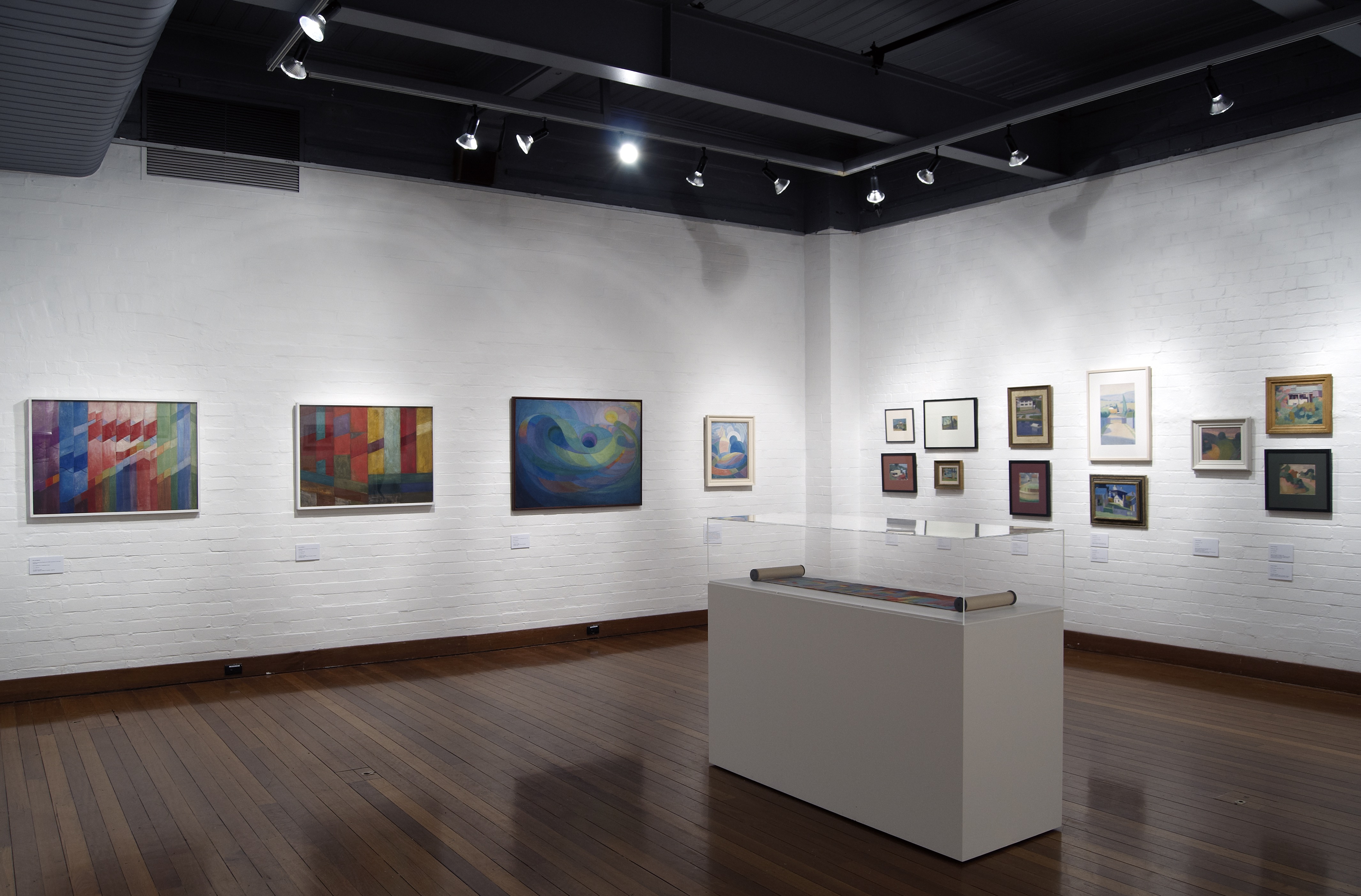 Installation showing framed modernist and abstract paintings exploring colour theory, arranged in a minimalist gallery space.
