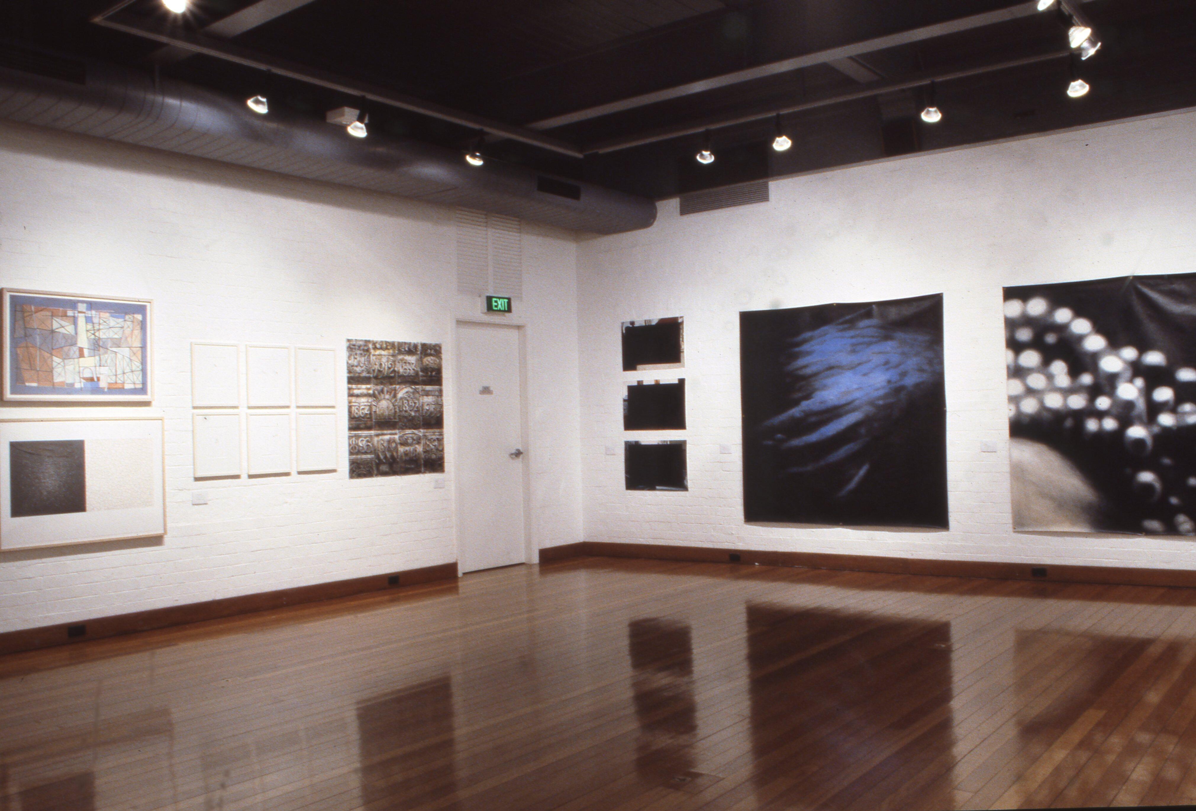 minimalist white-walled gallery interior with multiple framed artworks arranged in a horizontal sequence along the wall 