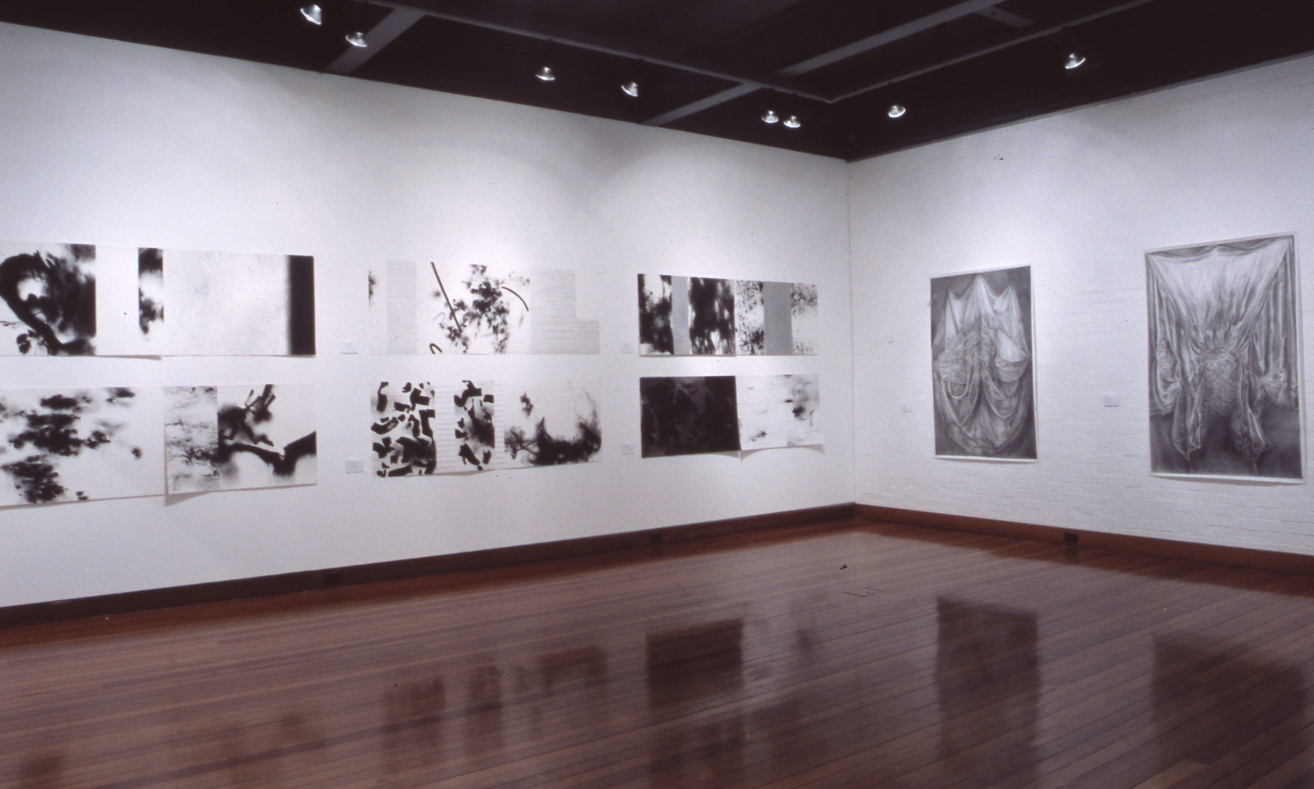 Installation featuring multiple prints, and drawings arranged directly on the wall in a structured layout.
