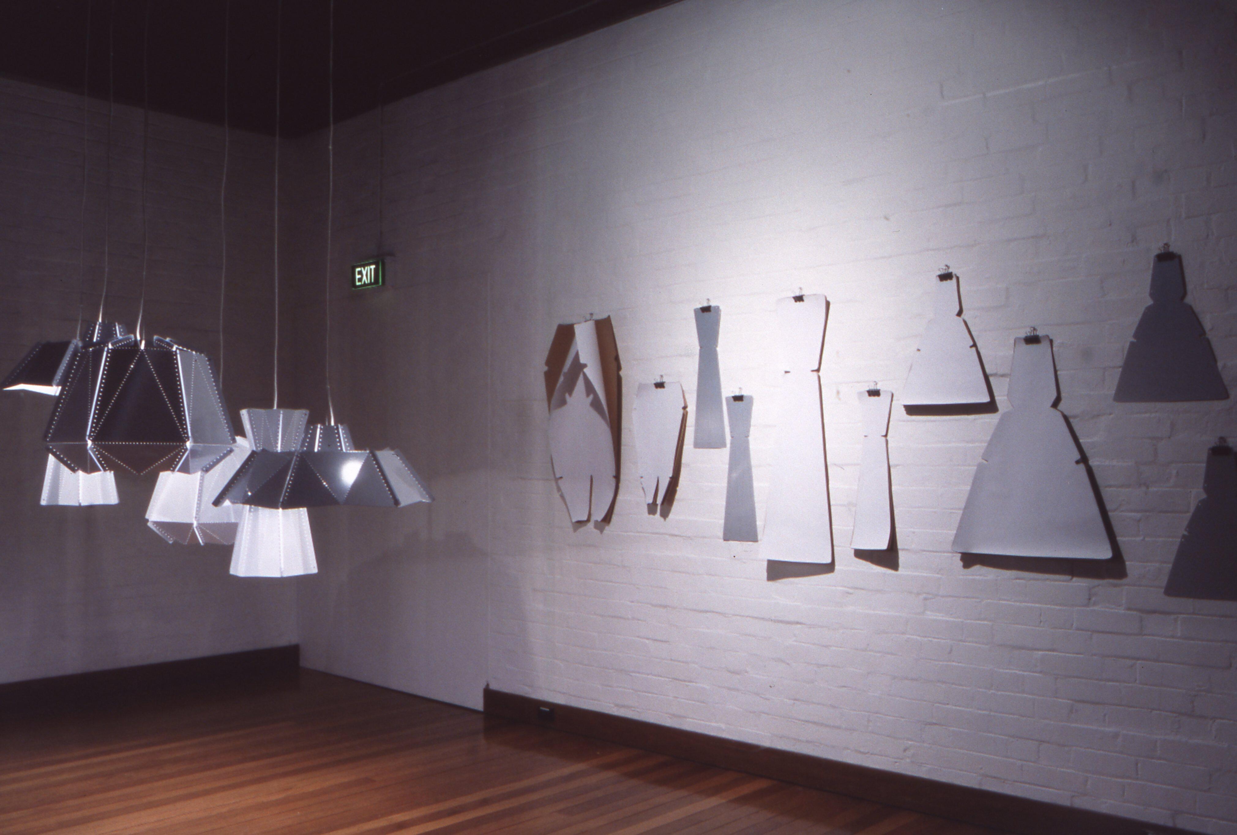 A scene featureing sculptural and installation-based works that emphasize material experimentation, light, and form, including suspended elements and modular objects