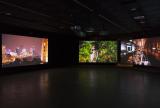 Installation view of three screens each playing a video simultaneously