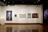 Interior with white walls, large framed artworks, scattered sculptures