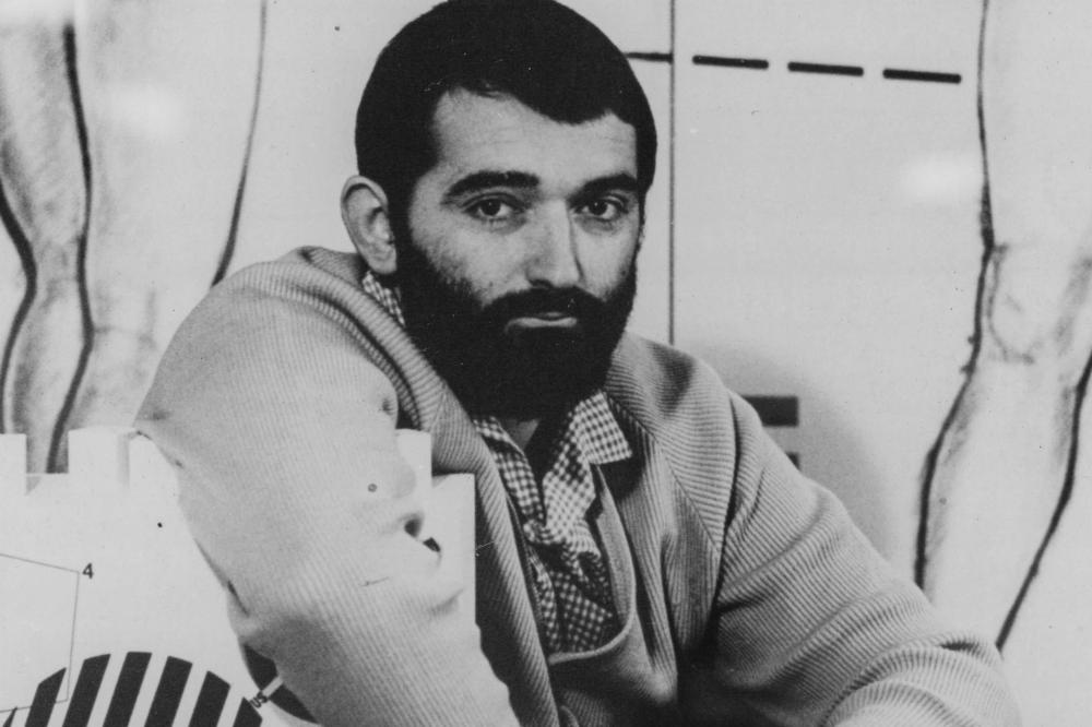 A man sitting behind a painting 